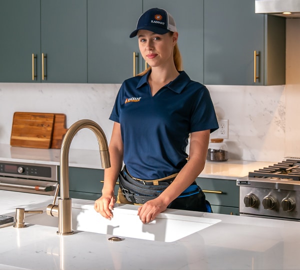 Radiant of Austin plumber standing by a kitchen sink
