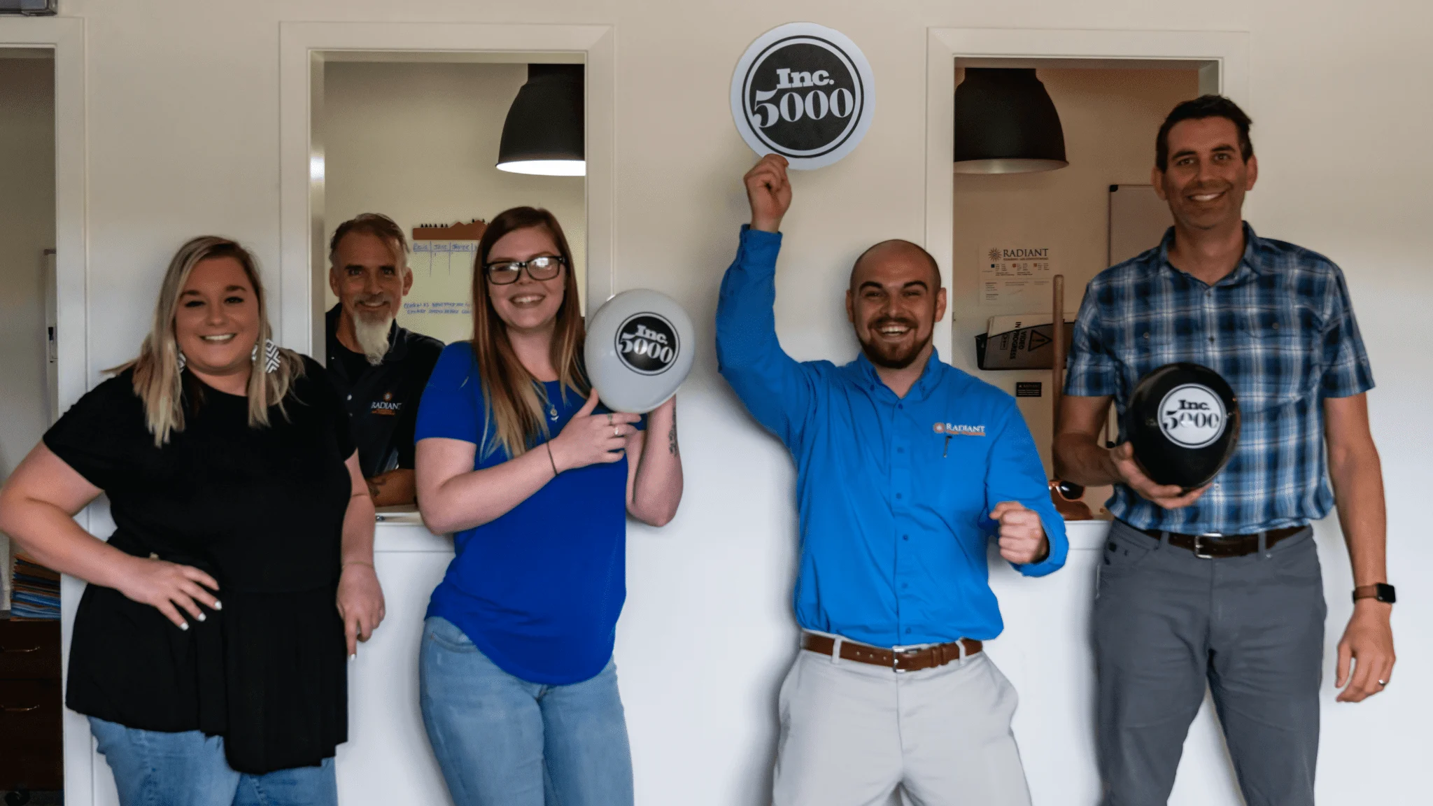 Employees of Radiant Plumbing, Air Conditioning, & Electrical waiving INC 500 balloons in celebration