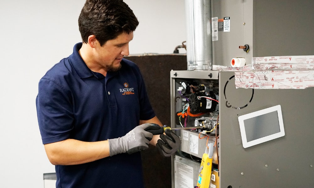 A Radiant HVAC technician repairing a furnace in Austin, TX