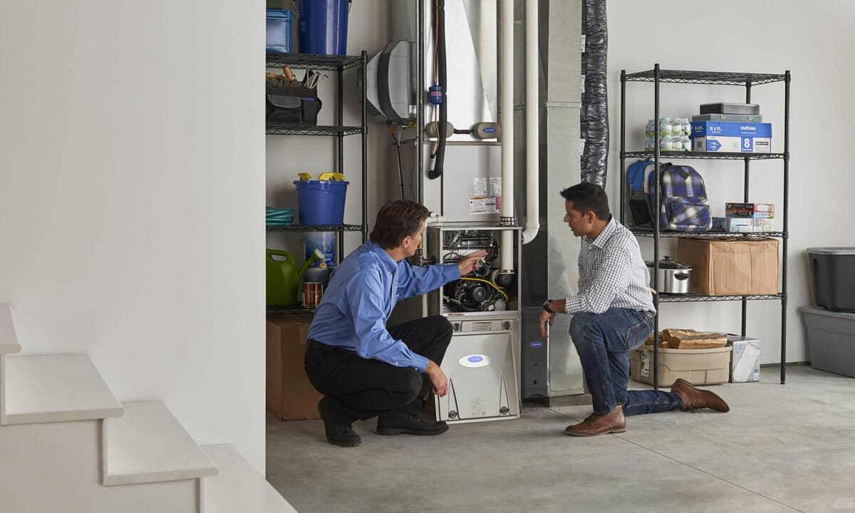 An HVAC technician discussing a furnace with a homeowner