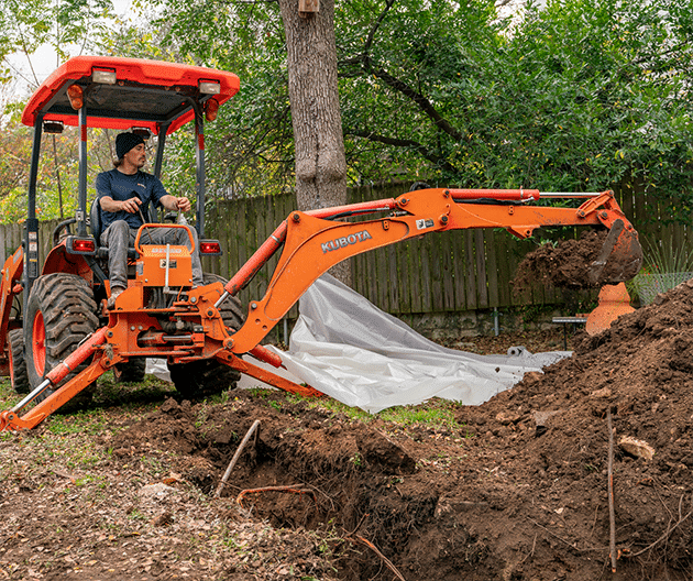 Radiant technician operating an excavating digger at a home yard
