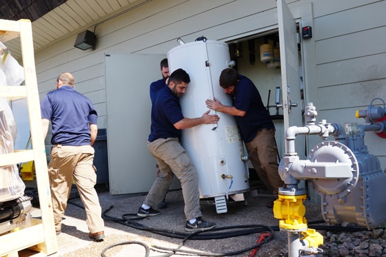 Multiple Radiant Plumbing technicians installing a water heater in a home