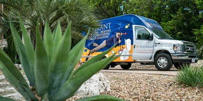 A Radiant Plumbing truck driving across the Texas desert landscape