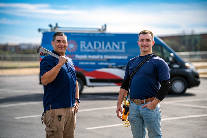 Two Radiant Technicians standing in front of a Radiant vehicle