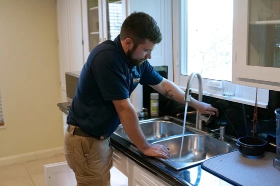 A Radiant Technician checking the water flow from a kitchen faucet