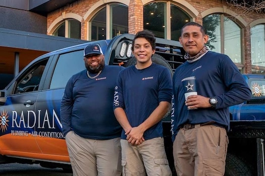 Radiant Plumbing and Air technicians standing in front of the office and trucks