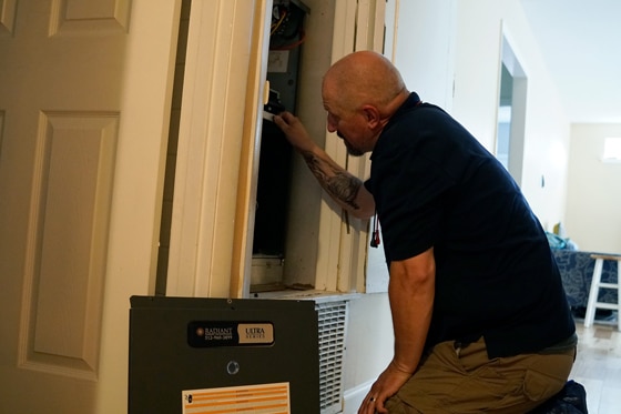 Radiant technician checking an indoor HVAC unit in a closet