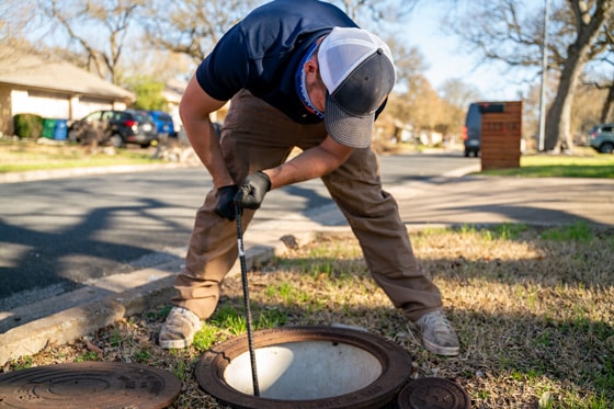 Radiant technician clearing out a sewer drain in the yard