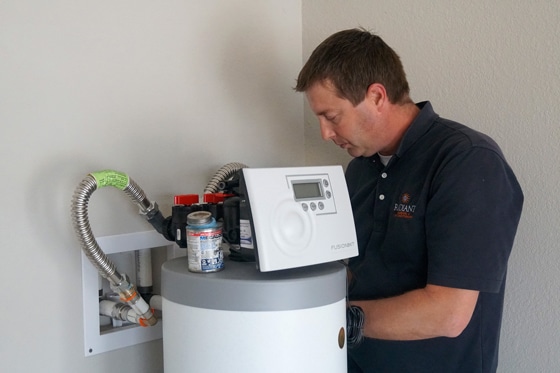 Radiant technician installing a water softener in a home