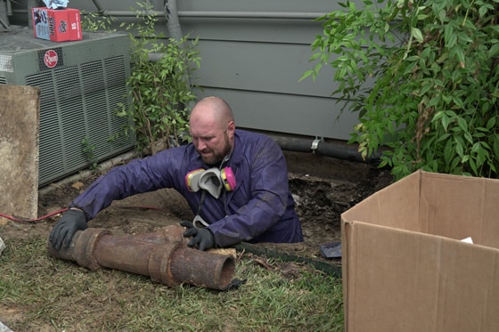 Radiant technician pulls old pipes from crawl space under a home
