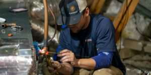 Radiant technician repairing an HVAC unit in an attic