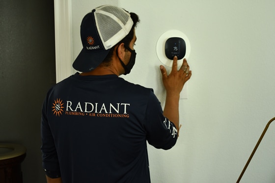 Radiant technician setting up smart thermostat in home