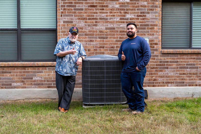 A Radiant technician standing with a veteran next to an AC unit