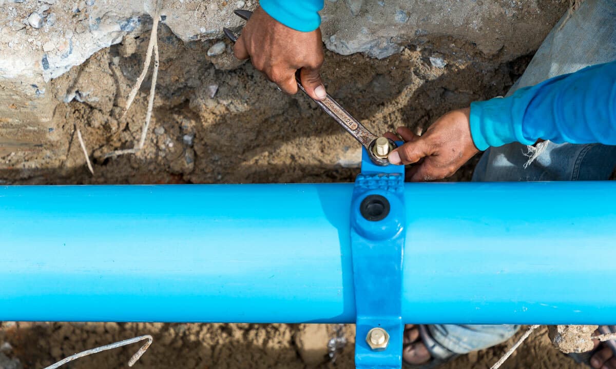 A plumber fixing a sewer line in the ground