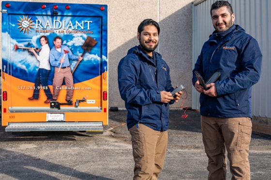 Two Radiant Plumbing technicians in front a work truck