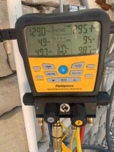 Fieldpiece refrigerant manifold showing pressure and temperature readings during HVAC startup
