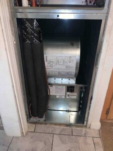 Air handler with the blower section exposed during HVAC installation inside the home.