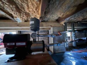 pressure booster pump and expansion tank connected to updated copper piping under home