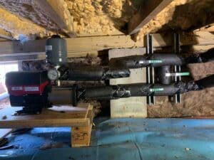 water pressure booster pump installed under home with insulated supply lines