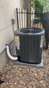 Trane air conditioning condenser installed on pad next to home exterior in Round Rock