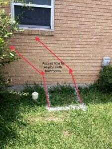 Marked exterior wall showing planned access points for tunnel excavation to re-pipe both bathrooms.