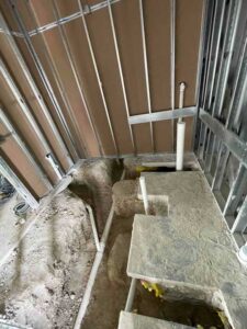 Interior commercial plumbing rough-in with drain pipe layout in Kyle construction site