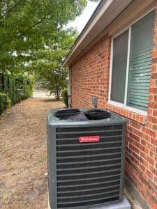 A new Goodman HVAC condenser installed properly outside a home