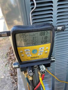 Digital refrigerant gauge showing operating pressures and temperatures on a newly installed Trane HVAC system.