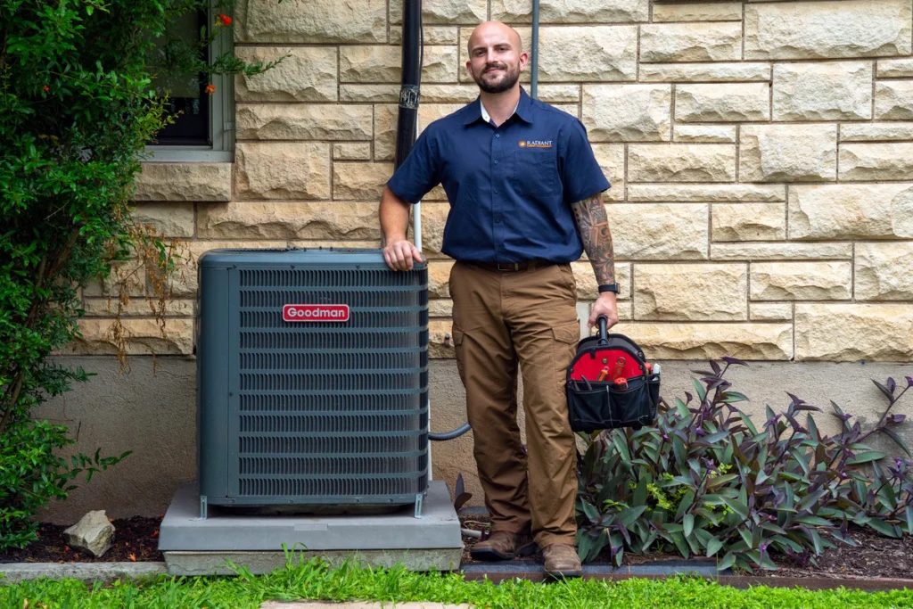 Radiant technician beside the outdoor condenser that a new Austin furnace must be matched to