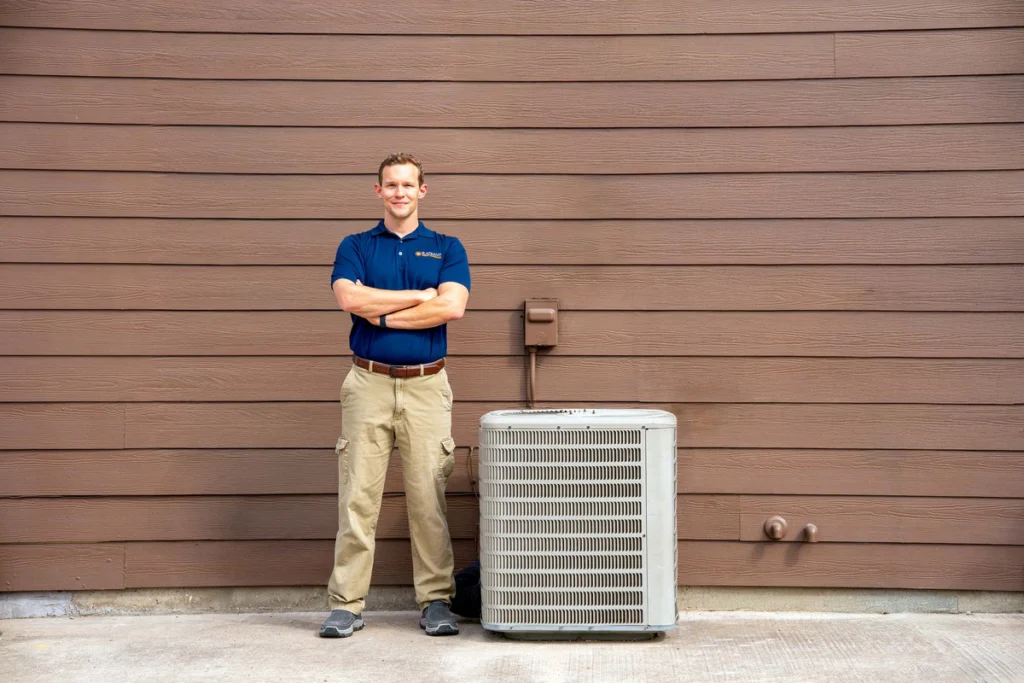Radiant HVAC technician beside an outdoor air conditioner at a San Antonio home