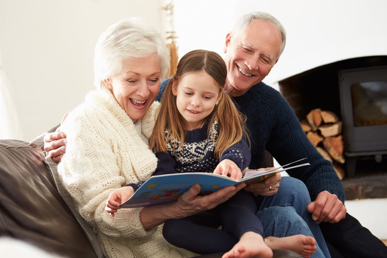 A family sitting happily together on the couch reading