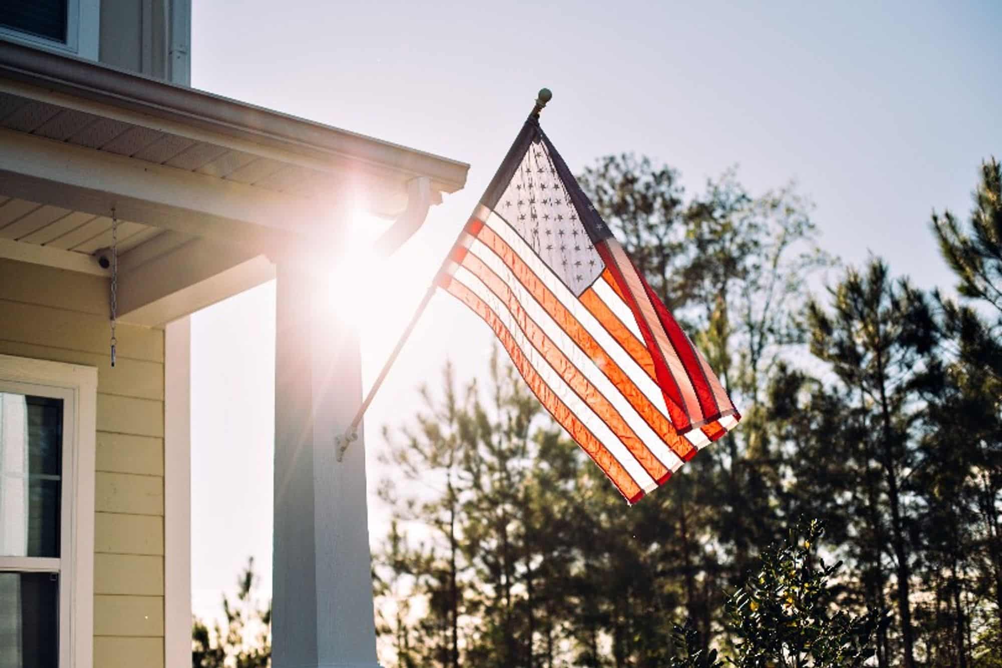 An American flag flying outside a home at sunset