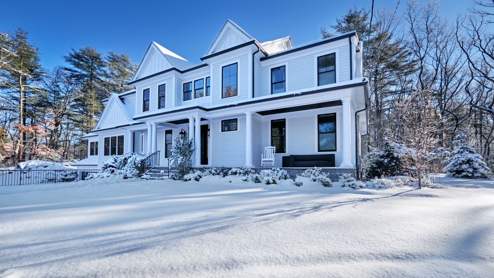 modern single family home covered in snow