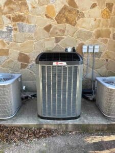 New Trane XR16 outdoor condenser installed on the existing equipment pad with updated electrical connections.