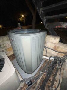 A new AC condenser outside on a slab of concrete