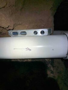 Level confirming correct slope on newly installed sewer line to ensure proper drainage flow.