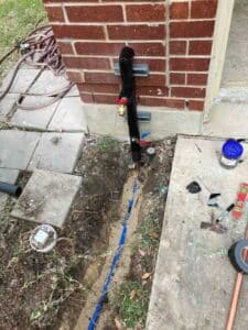 Exterior water line and shutoff valve connection at home foundation