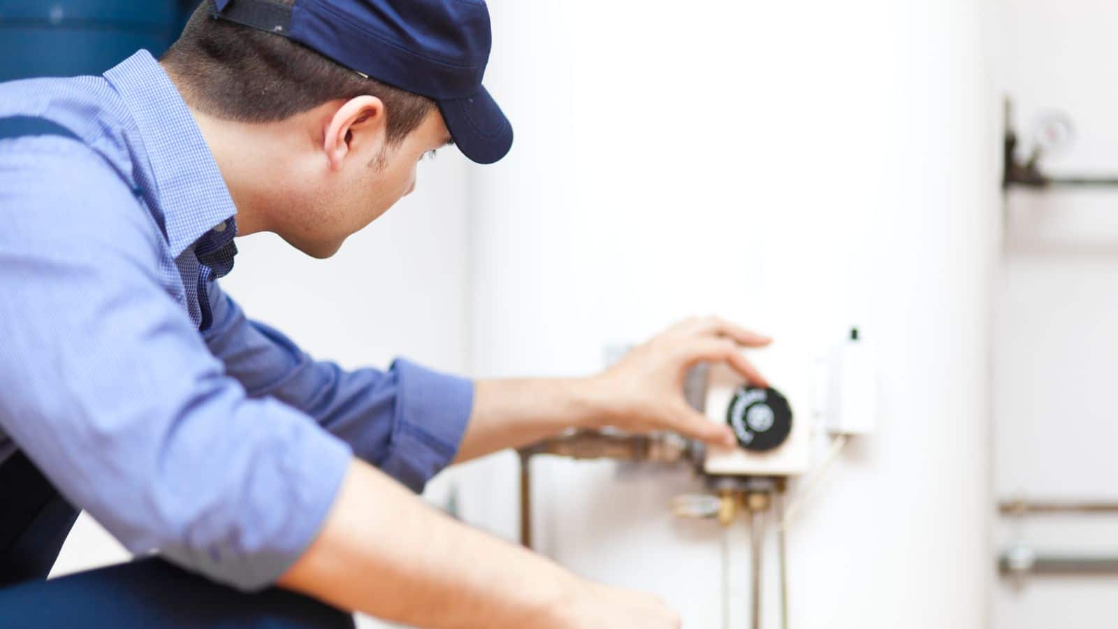 Plumber adjusting the temperature on a water heater