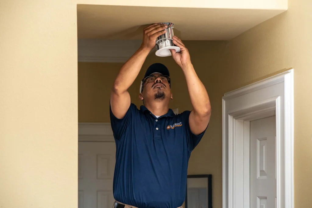 Radiant electrician working at a ceiling box before mounting a ceiling fan in an Austin home