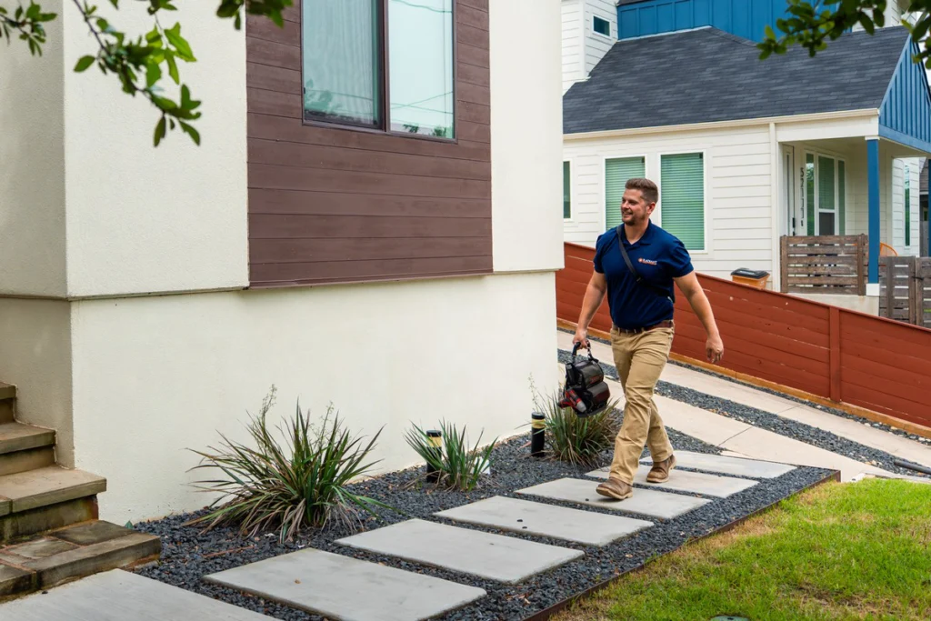 Radiant technician heading up the front walk for a San Antonio furnace tune-up