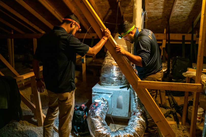 Radiant HVAC technicians install an air handler and ducting to an attic