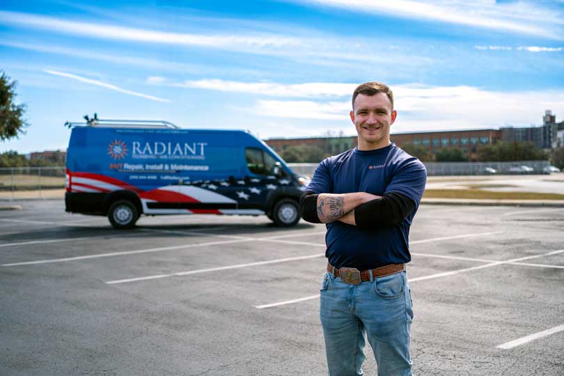 A Radiant technician standing in front of the company truck in a parking lot
