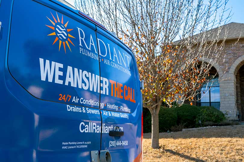 Up close of the back of the Radiant Plumbing & Air Conditioning van parked in front of the house