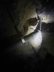 PVC sewer line with new fittings installed under home during drain replacement