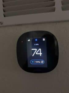 Ecobee smart thermostat showing indoor cooling temperature and system status.