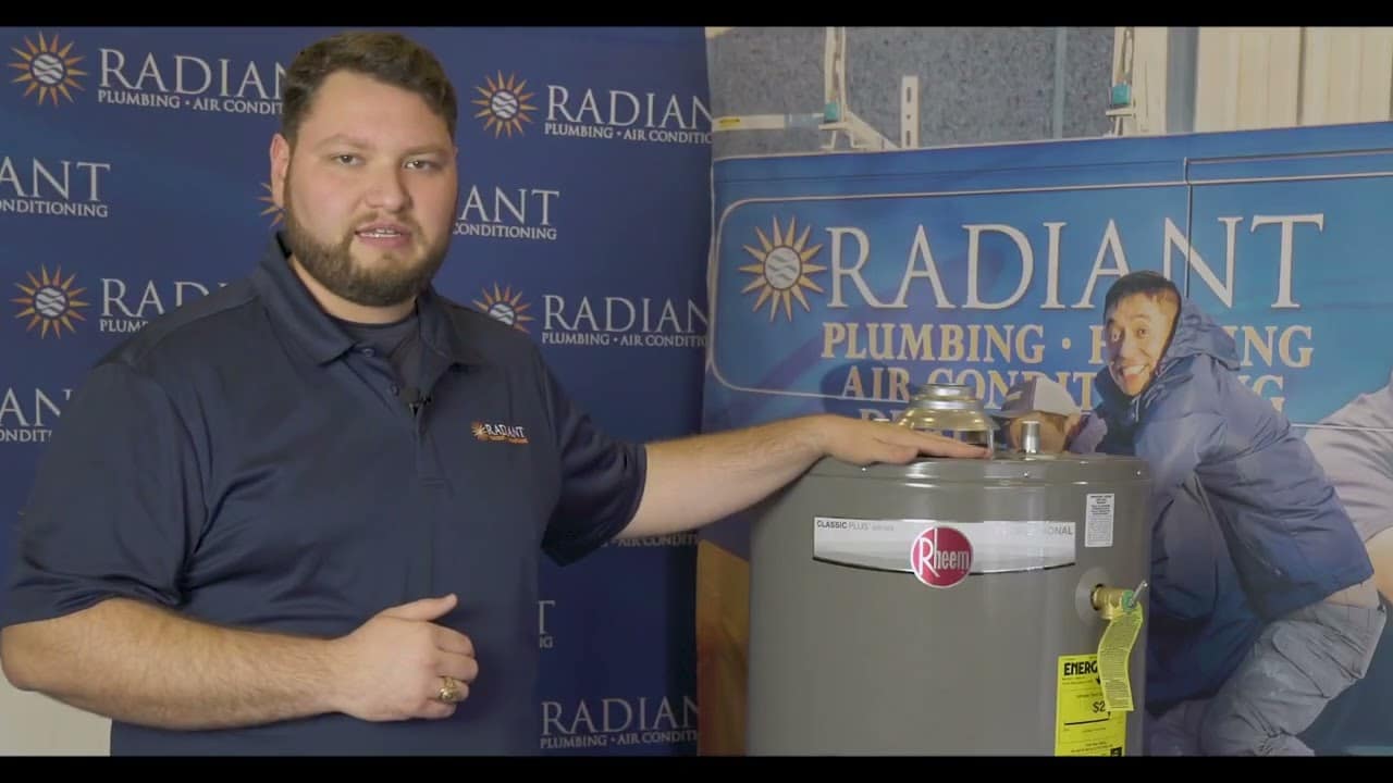 Radiant technician with hand on a tanked water heater