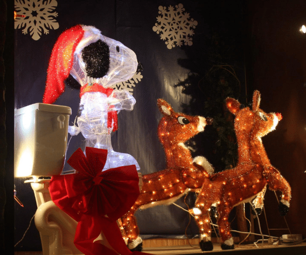 Christmas display with Snoopy sitting on the toilet and reindeer pulling him