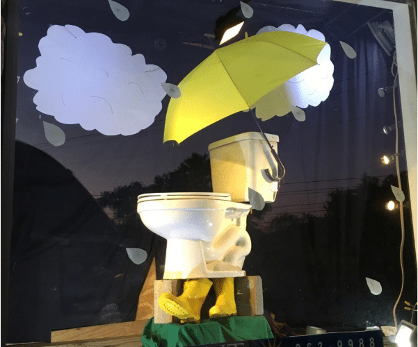 Toilet display at Radiant Austin office with a springtime shower theme, similar to the Morton Salt Girl logo