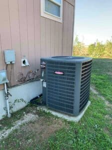 Newly installed Trane condenser placed on a concrete pad outside the home.
