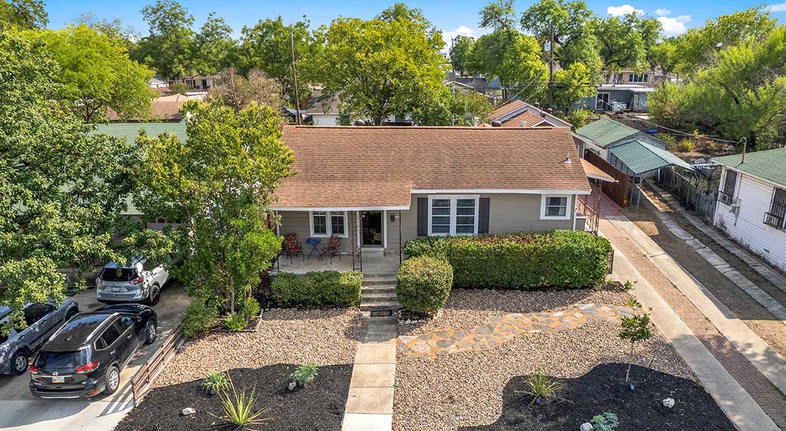 A typical Texas home with desert landscaping and a car in the driveway